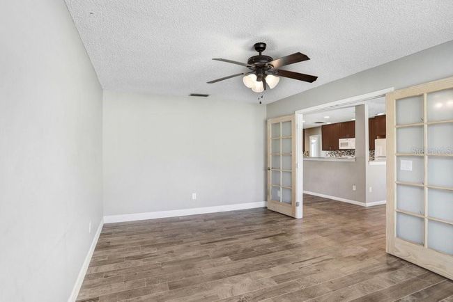 Office with sliding doors that open to the living room, kitchen and dining area | Image 12