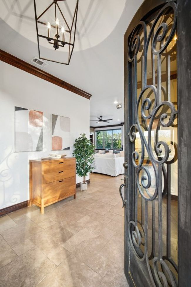 Entrance foyer featuring a chandelier, visible vents, baseboards, and ornamental molding | Image 8