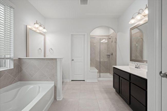 Primary bathroom with a bath, a stall shower, tile patterned floors, and vanity | Image 24