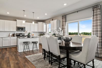 (Photo of decorated model, actual home's finishes will vary) Soaked in natural sunlight, the homes eat-in dining room has ample space for a dining table located in the heart of the home. | Image 3