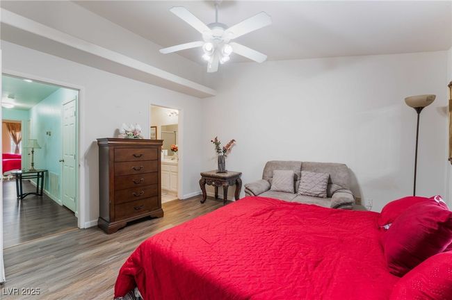 Bedroom featuring wood finished floors, connected bathroom, a ceiling fan, and baseboards | Image 28