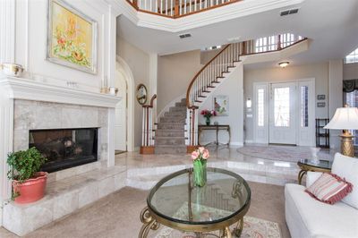 Living room featuring a fireplace and a high ceiling | Image 3