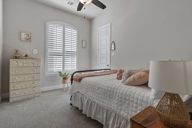 Carpeted bedroom with visible vents, baseboards, and a ceiling fan | Image 21