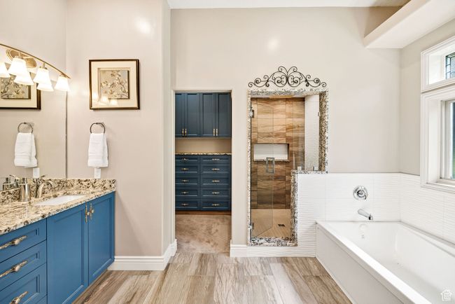 Bathroom with vanity, a bath, and a shower stall | Image 34