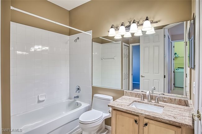 Full bathroom featuring tiled shower / bath combo, toilet, washer / clothes dryer, and vanity | Image 37