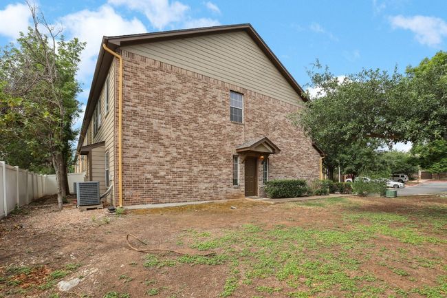 View of front facade featuring fence, central AC unit, and brick siding | Image 35