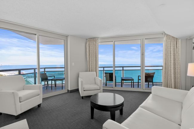Living room with carpet, expansive windows, and a water view | Image 6