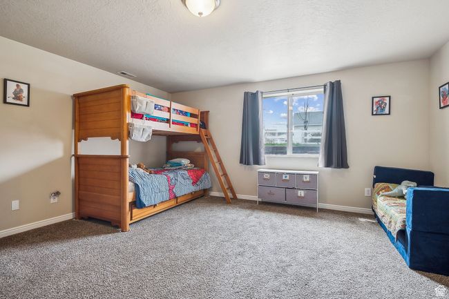 Carpeted bedroom with baseboards, a textured ceiling, and visible vents | Image 48
