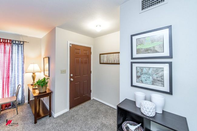 Carpeted entrance foyer featuring baseboards and visible vents | Image 7
