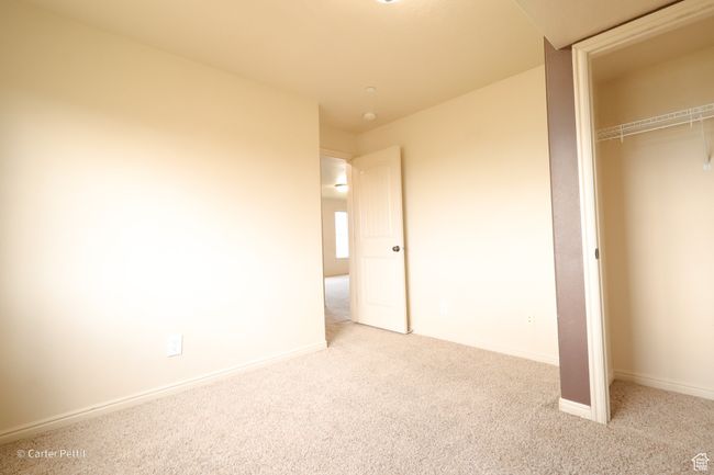 Unfurnished bedroom with carpet flooring and a closet | Image 10