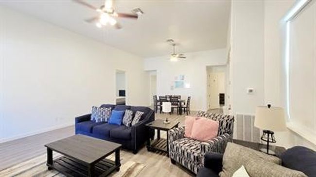 Living room with a ceiling fan and light wood-type flooring | Image 5