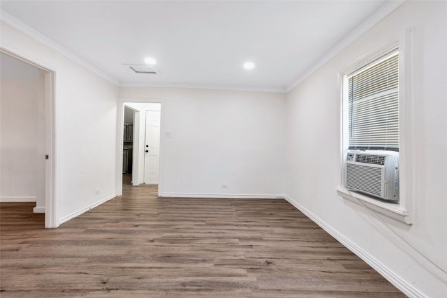 Empty room with ornamental molding, wood finished floors, recessed lighting, and cooling unit | Image 12