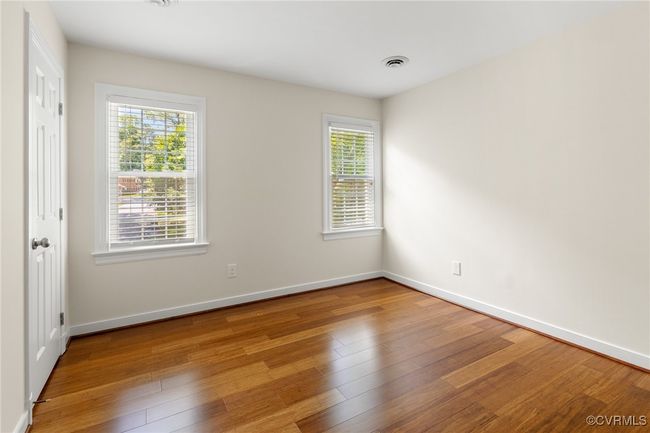 Bedroom 2 with healthy amount of natural light, laminated wood flooring, and door to closet/walk-up attic. | Image 31