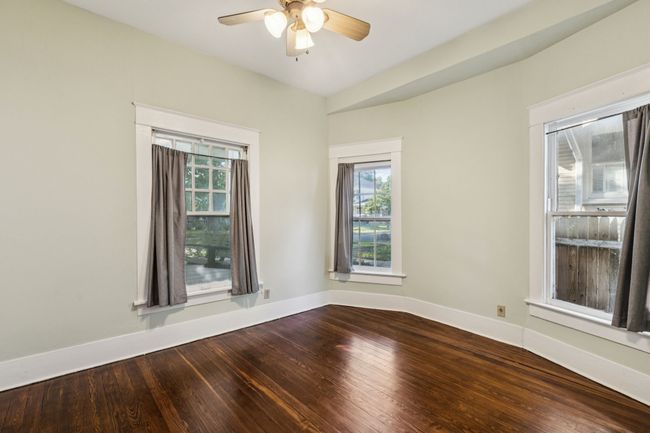 Unfurnished room with a ceiling fan, dark wood-style flooring, plenty of natural light, and baseboards | Image 13