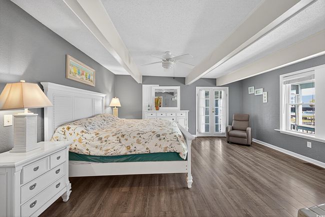 Bedroom featuring dark wood-style flooring, a textured ceiling, a ceiling fan, and french doors | Image 11