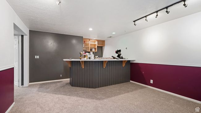 Bar with a bar, carpet floors, baseboards, and recessed lighting | Image 18