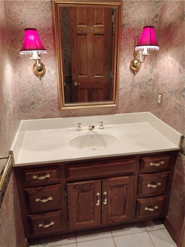 Downstairs half Bathroom featuring wallpapered walls, vanity, and tile patterned flooring | Image 57