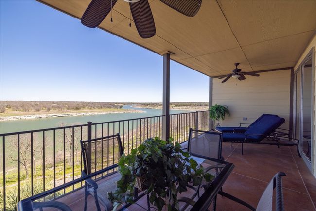 Balcony with ceiling fan and a water view | Image 15