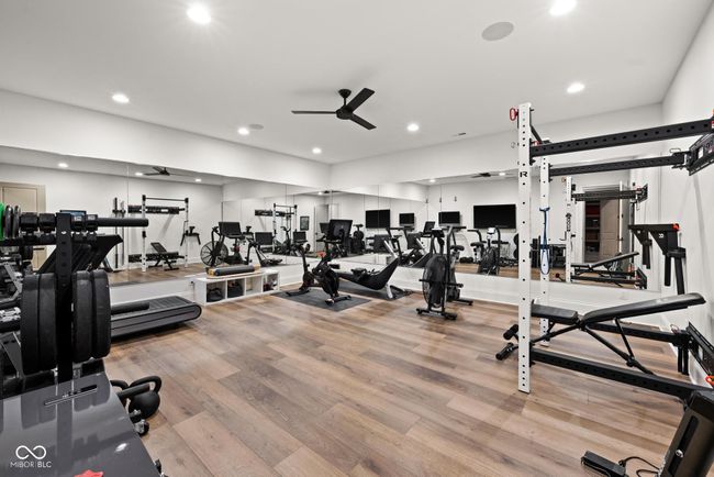 exercise room featuring a ceiling fan, wood finished floors, and recessed lighting | Image 87