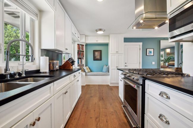 Custom built in benches and shelving in the kitchen provide additional storage and works well as a dining nook or additional seating area. | Image 15