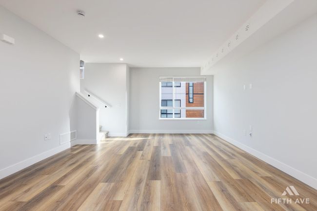Unfurnished living room featuring stairs, wood finished floors, and recessed lighting | Image 6