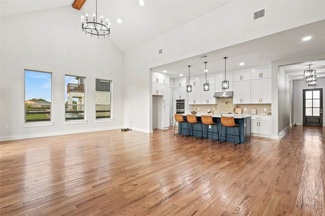 Unfurnished living room featuring a chandelier, light wood-type flooring, high vaulted ceiling, recessed lighting, and beam ceiling | Image 8