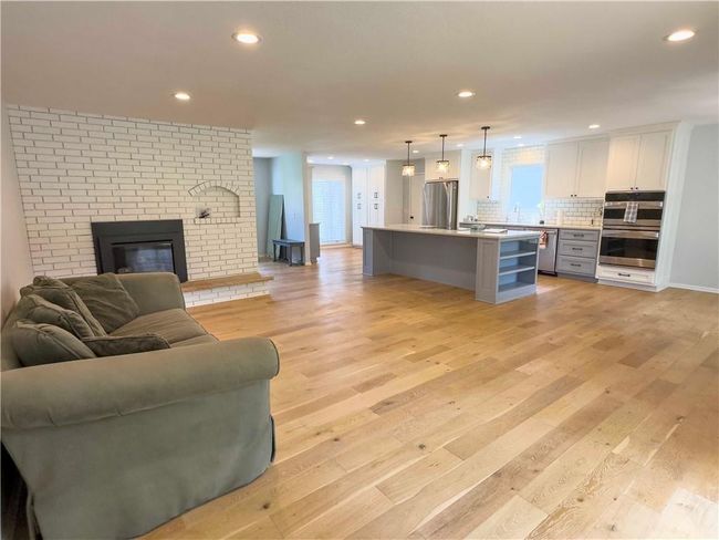 Living area featuring light wood-style flooring, a wealth of natural light, and recessed lighting | Image 18