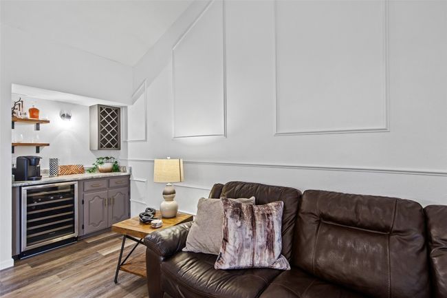 Living area with beverage cooler, bar with sink, and light wood-style flooring | Image 11