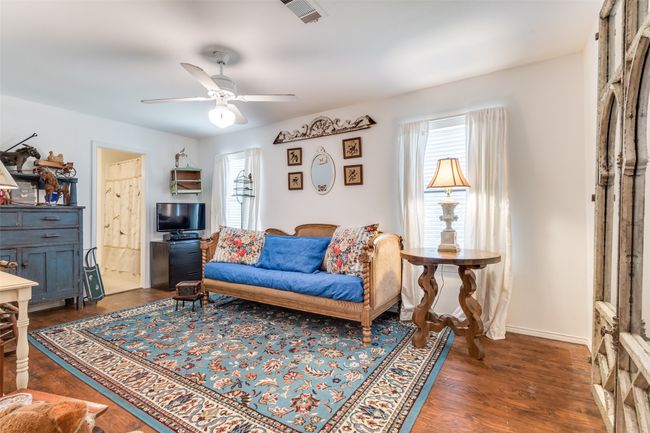 Bedroom with ceiling fan, dark wood finished floors, and baseboards | Image 23
