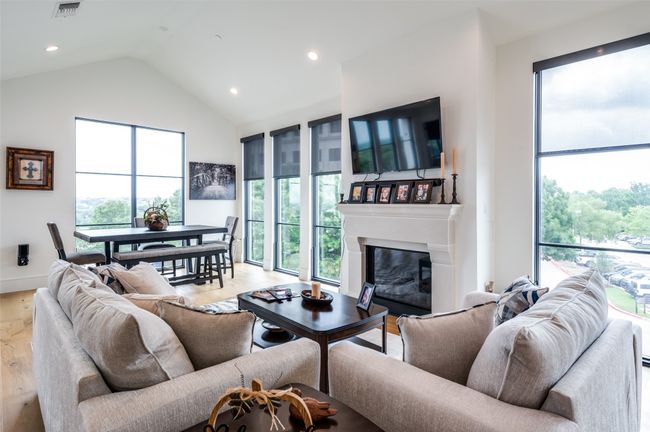 Pretty living room filled with natural lights from walls of windows, so light and bright and cheery. | Image 5