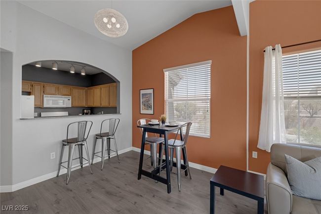 Dining space with baseboards, arched walkways, wood finished floors, and lofted ceiling | Image 12