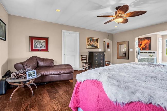 Bedroom featuring wood finished floors, arched walkways, recessed lighting, and ceiling fan | Image 20