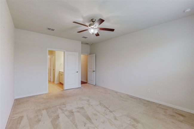 Unfurnished bedroom with light carpet, baseboards, ceiling fan, and ensuite bath | Image 24
