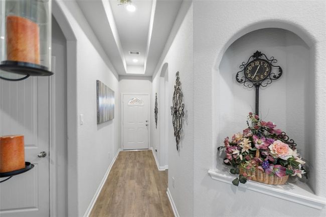 Entryway hallway leading to secondary rooms and bathroom. | Image 4