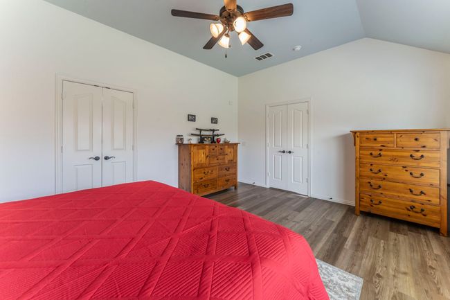 Bedroom featuring wood finished floors, vaulted ceiling, and ceiling fan | Image 12