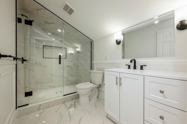 Full bath with visible vents, toilet, vanity, a marble finish shower, and marble finish floor | Image 7