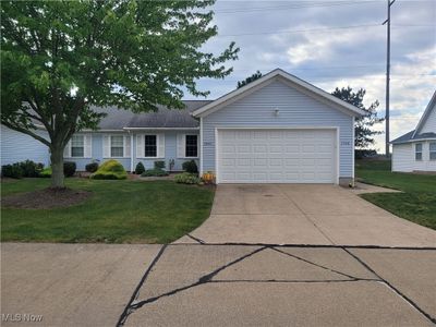 Ranch-style house with a garage and a front lawn | Image 1