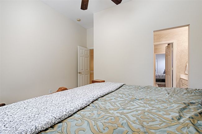Bedroom featuring a ceiling fan, high vaulted ceiling, and ensuite bathroom | Image 20