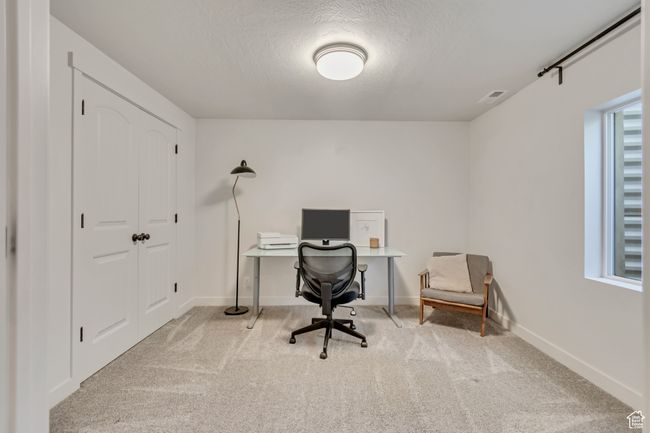 Carpeted office space with a textured ceiling and baseboards | Image 28