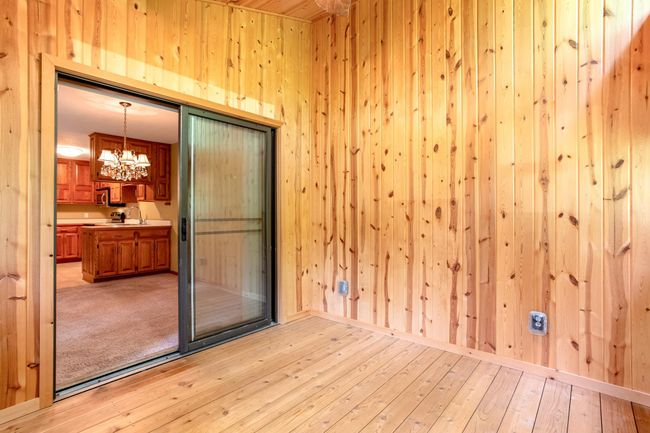 Rustic wood finishes and vaulted ceilings create a cozy, sunlit space perfect for morning coffee or evening unwinding. | Image 14