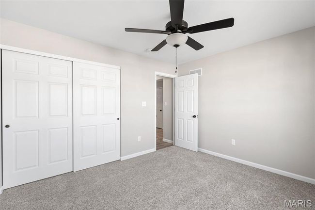 Unfurnished bedroom featuring carpet floors, baseboards, a closet, and ceiling fan | Image 4