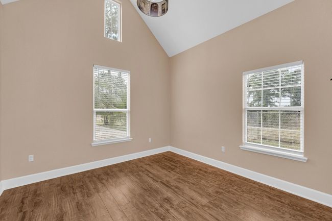 Spare room with dark wood-type flooring and high vaulted ceiling | Image 24