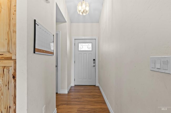 Doorway to outside featuring wood finished floors and a chandelier | Image 12