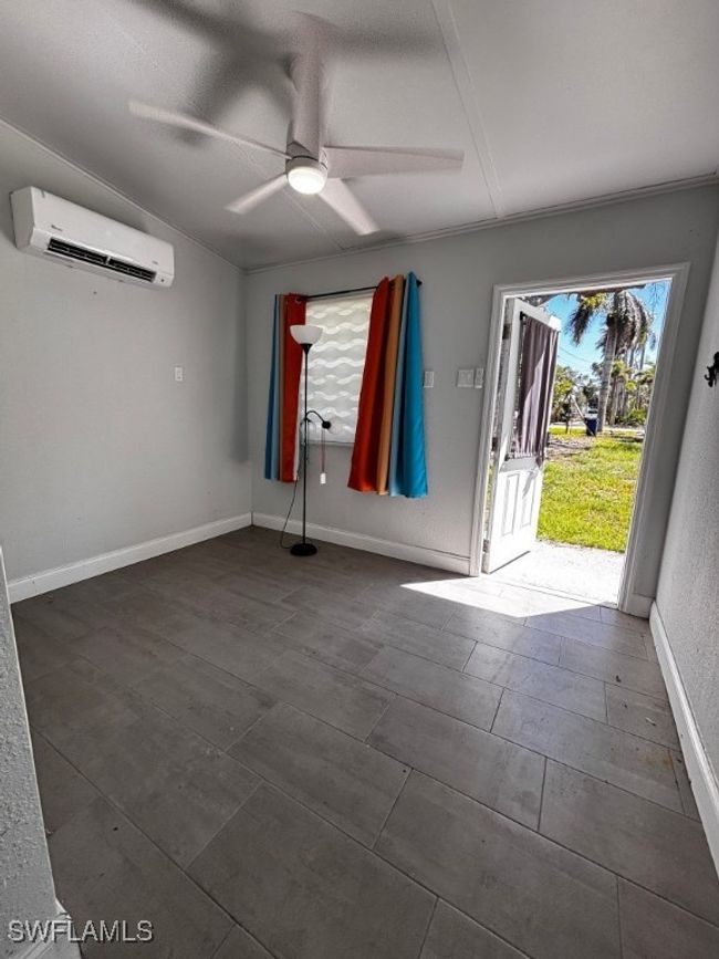 Bedroom view with outside access, wall air unit and ceiling​​‌​​​​‌​​‌‌​‌‌​​​‌‌​​‌‌​‌​​​​​‌ fan. | Image 5