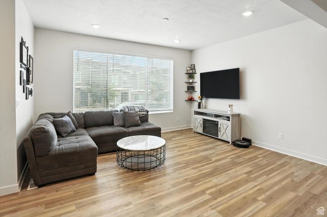 Living area with new light wood-style LVP floors and recessed lighting | Image 25