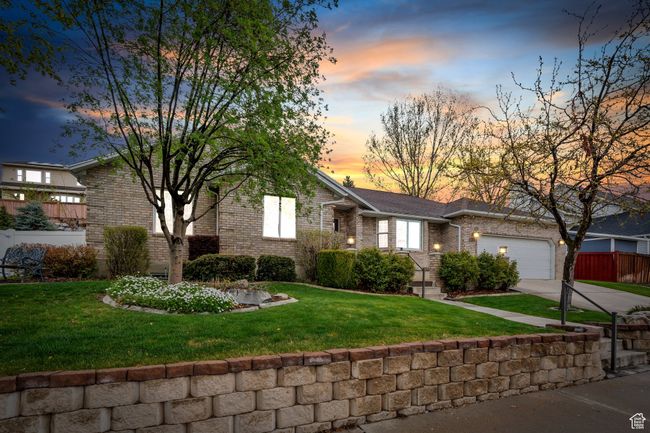 View of front facade with a front lawn, driveway, fence, brick siding, and a garage | Image 47