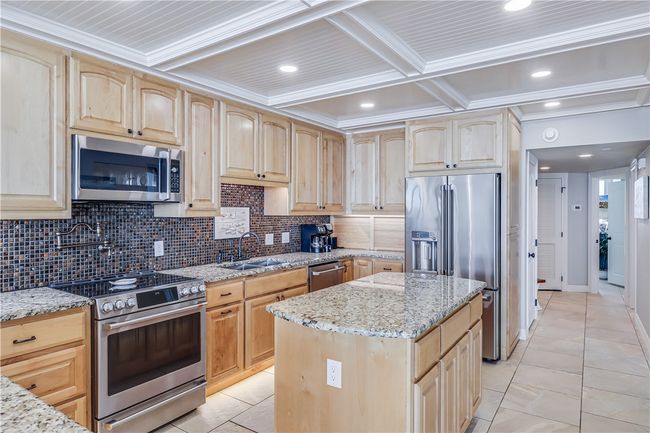 Lots of granite counter space and an island with cutting board. | Image 5