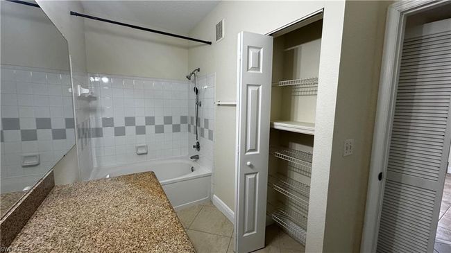 Full bath featuring baseboards, visible vents, tile patterned flooring, and shower combination | Image 6
