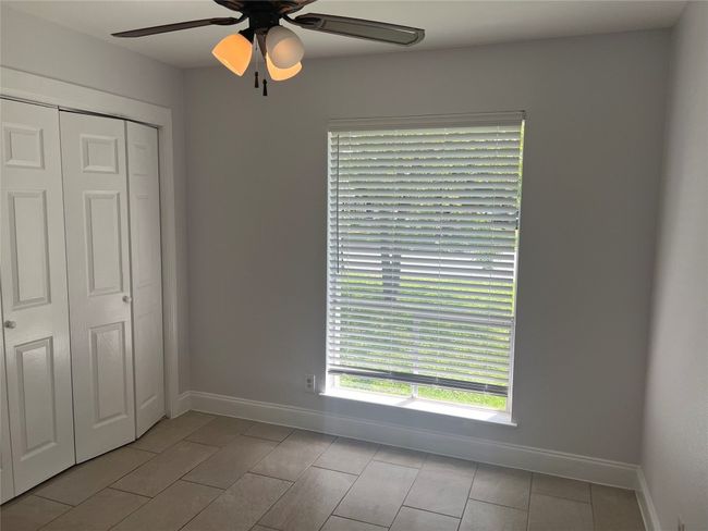Unfurnished bedroom with a closet, a ceiling fan, and light tile patterned floors | Image 13