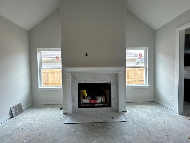 Unfurnished living room with a premium fireplace and vaulted ceiling | Image 7